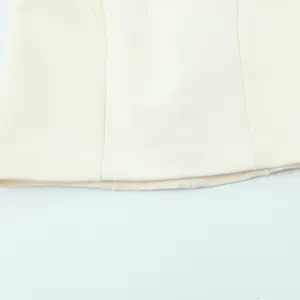 Detail shot showing the clean hemline of a fashionable cream white puffy mini dress