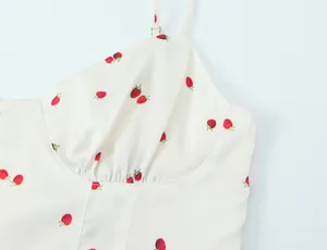 Close-up view of a strawberry print on a white satin camisole showing fabric detail