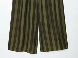 Detail view of olive green and black vertical striped wide-leg trousers with loose fit