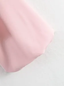 Vue macro d'un détail de manche ballon rose sur un blouson bomber, texture du tissu.