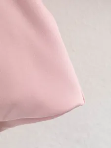 Gros plan macro détaillé du tissu tissé rose de haute qualité sur une veste bomber mode.