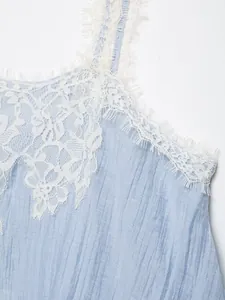 Close-up detail of a light blue crop top featuring delicate white lace trim and straps.
