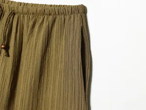Close-up of olive green wide-leg pants with elastic waist and crinkle texture