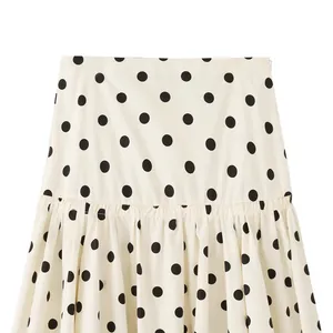 Stylish white polka dot mini skirt with mid-waist and elegant pleated design details