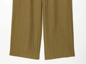 Detail of olive green crinkle fabric wide leg pants showing the textured finish