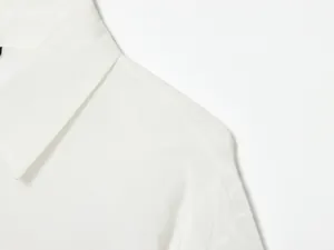 Close-up van een modieus wit shirt met delicaat opengewerkt borduursel op de mouw