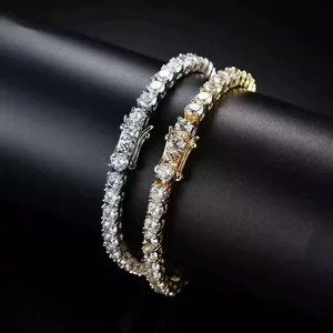 Primo piano di bracciali tennis hip-hop color oro e argento con pietre di zirconi chiari.