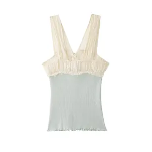 Detailweergave van een tweekleurige geribbelde tanktop met crèmekleurige ruches en blauw lichaam