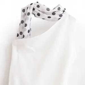 Elegant white halter dress featuring a chic black and white polka dot scarf neck design.