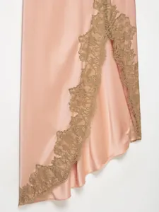 Close-up of intricate olive green lace trim on a pink silk-like satin dress hem.