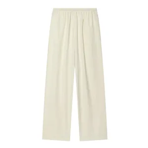 Close-up of cream wide-leg pants with elastic waist and textured fabric