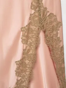 Close-up detail of pink satin dress featuring intricate brown floral lace trim decoration