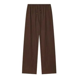 Detailed macro view of brown crinkle textured wide leg trousers with a drawstring waist