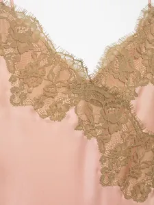 Detail view of exquisite gold floral lace trim on an elegant rose gold silk-satin dress