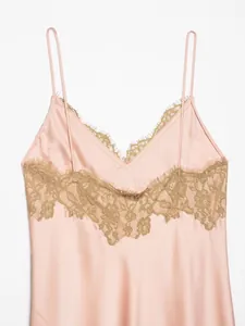 Detailed macro view of an elegant pink satin slip dress featuring delicate green lace trim