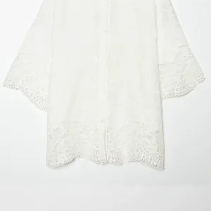 Elegante witte blouse met opengewerkt borduursel, bloemenpatronen en geschulpte kant aan de zoom