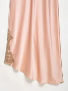 Macro view showing the delicate lace trim and smooth satin fabric of a pink dress.