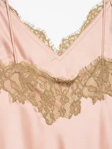 Close-up of delicate lace trim on a pink satin dress with V-neckline detail.