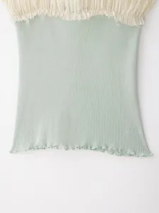 Detailopname van de geribbelde textuur en golvende zoom van de mintgroene modieuze top