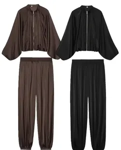 Satin two-piece set featuring a pleated bomber jacket and matching harem pants in brown and black