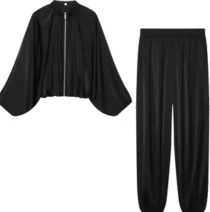 Elegant black satin two-piece outfit featuring a puff sleeve bomber jacket and lantern pants