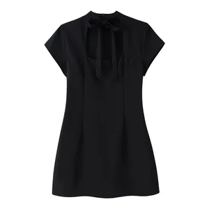 Detalle frontal de un minivestido negro de manga corta con abertura y lazo al cuello