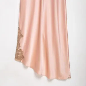 Elegant pink satin dress featuring delicate lace trim detail at the asymmetrical hemline