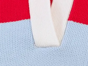 Détail en gros plan de la texture tricotée d'un pull à rayures rouges et bleues