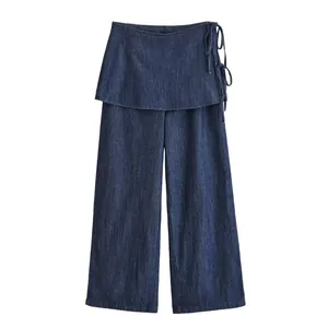 Detailweergave van donkerblauwe denim wijde pijpen met wikkelroklaag en zijstrikken.
