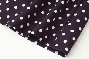 Detalle macro del dobladillo y el estampado de lunares blancos en tela negra suave