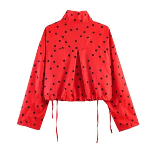Detailansicht der Rückseite einer roten Kurzjacke mit schwarzen Polka-Dot-Punkten.