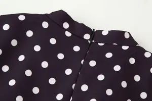 Primer plano detallado de la cremallera trasera en un vestido morado con lunares