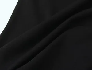 Close-up of the breathable black knitted fabric texture of a minimalist sleeveless T-shirt
