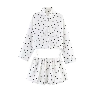Detailansicht eines weißen Damen-Sets aus Langarmshirt und Shorts mit schwarzen Punkten
