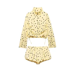 Detalle del conjunto amarillo de lunares con top corto de manga larga y pantalones
