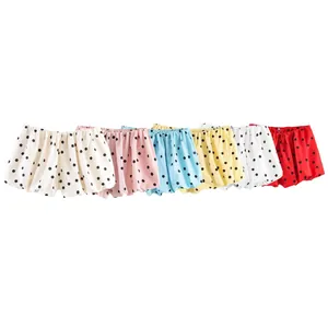 Vue détaillée de bloomers à pois colorés en rouge, bleu, jaune et rose vif.