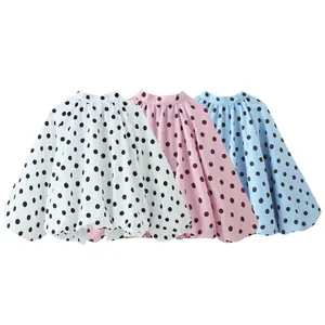 Detaillierte Ansicht modischer gepunkteter Langarmblusen in Weiß, Rosa und Blau.