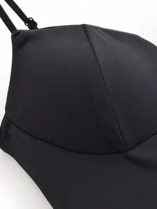 Detailaufnahme eines schwarzen eleganten Formtops mit glattem Stoff und Nähten