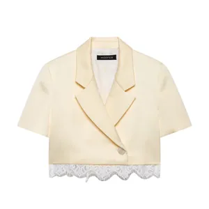 Detailed view of the cream short-sleeved cropped blazer with white lace patchwork hem