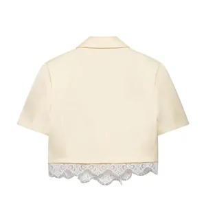 Detailed back view of an elegant cream cropped blazer featuring delicate white lace trim.