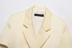 Close-up of cream short blazer collar showing high-quality fabric texture and label