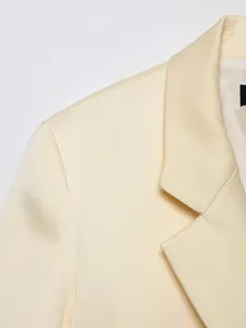 Detailed close-up view of the notch lapel and shoulder area of a cream women's blazer jacket.