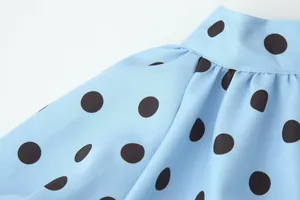 Detaillierte Nahaufnahme der blauen Polka-Dot-Bluse mit Kragen und schwarzen Punkten