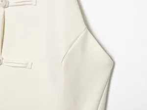 Detailansicht der eleganten Stoffknotenverschlüsse an einem weißen Neckholder-Oberteil