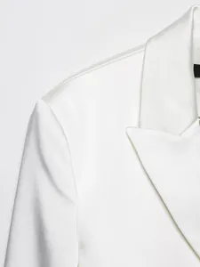 Dettaglio ravvicinato di un blazer in raso bianco con risvolto e tessuto di lusso