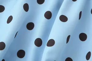 Detailansicht des glatten blauen Stoffes mit klassischem schwarzem Punktmuster Textur