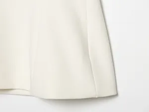 Detaillierte Nahaufnahme der feinen Stofftextur und des Saums des weißen Tops.