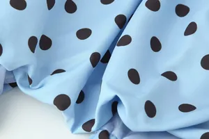 Detaillierte Makroansicht von hellblauem Stoff mit klassischem schwarzen Punktmuster