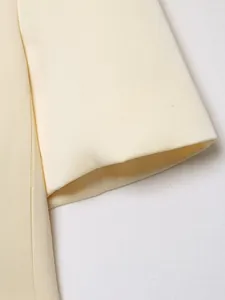 Close-up detail of the cream-colored short blazer sleeve showing high-quality fabric