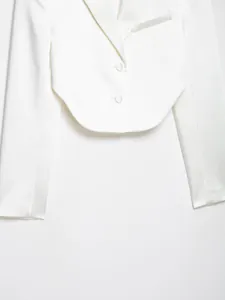 Dettaglio di un blazer corto in raso bianco con elegante rever e bottoni coordinati.